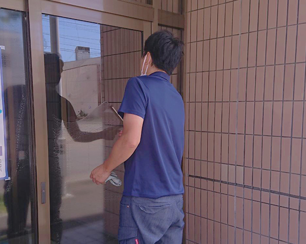 ハウスクリーニングのイメージ画像です。窓ガラスを拭く男性の画像が表示されています。
